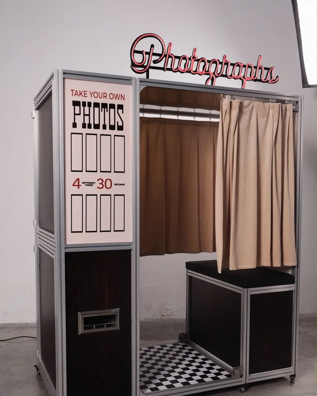 Vintage Booth, a vintage enclosed photo booth in Washington DC, with its red Photographs neon sign and velvet curtains