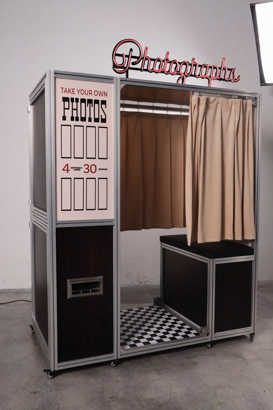 Vintage Booth, a vintage enclosed photo booth in Washington DC, with its red Photographs neon sign and velvet curtains
